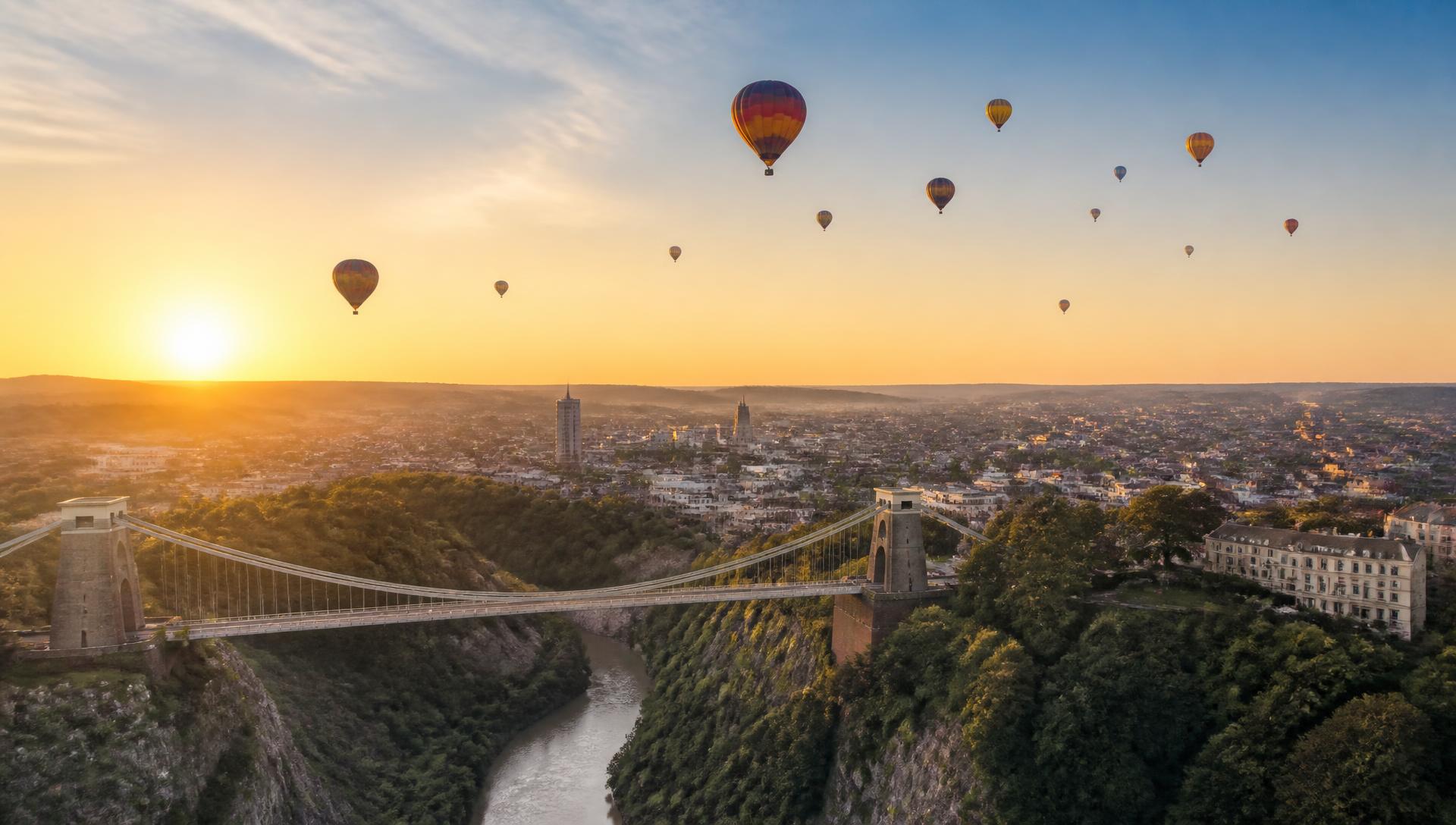 Hot air balloons rising over the Bristol skyline at sunrise